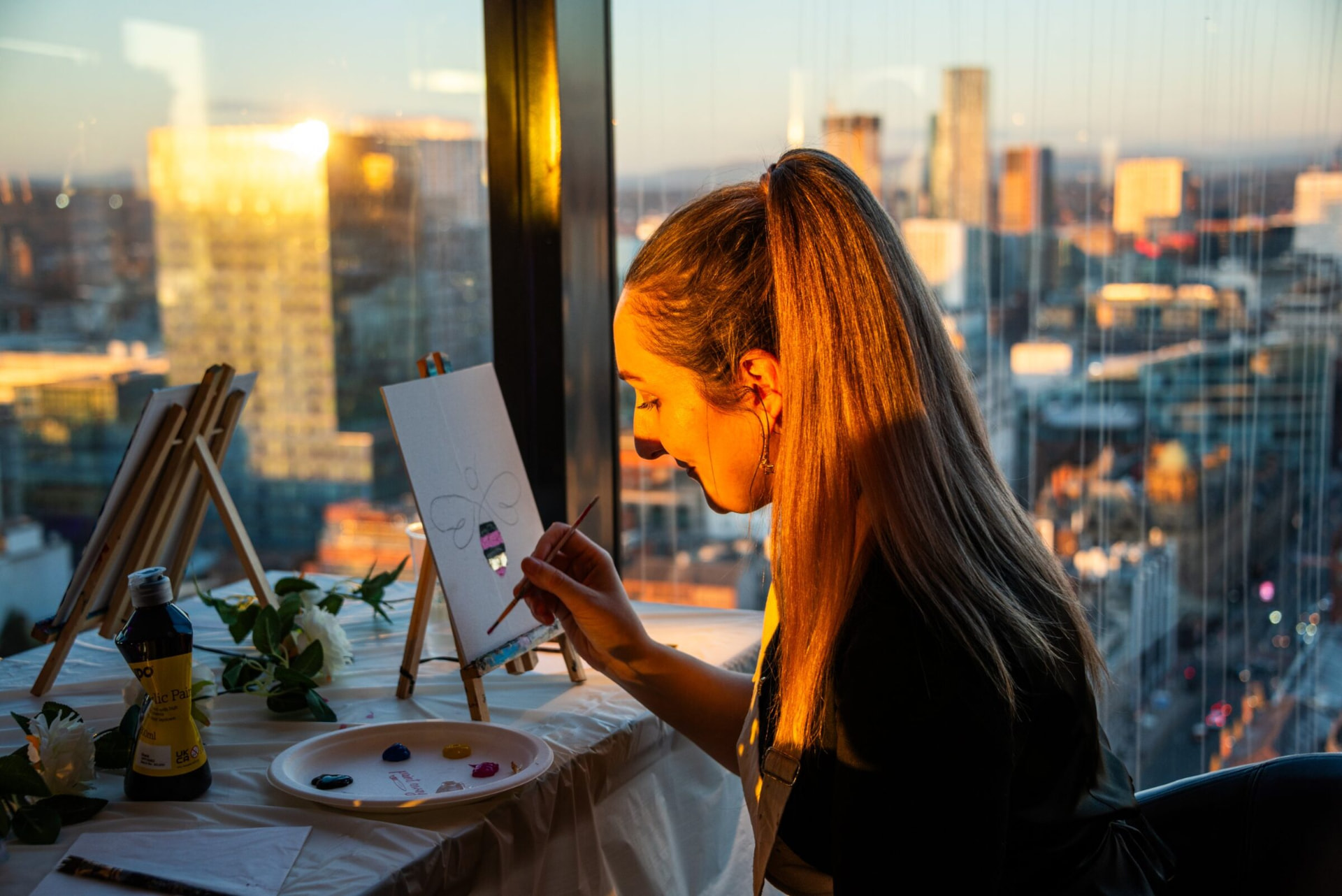Painting a bee at golden hour with the Manchester skyline behind