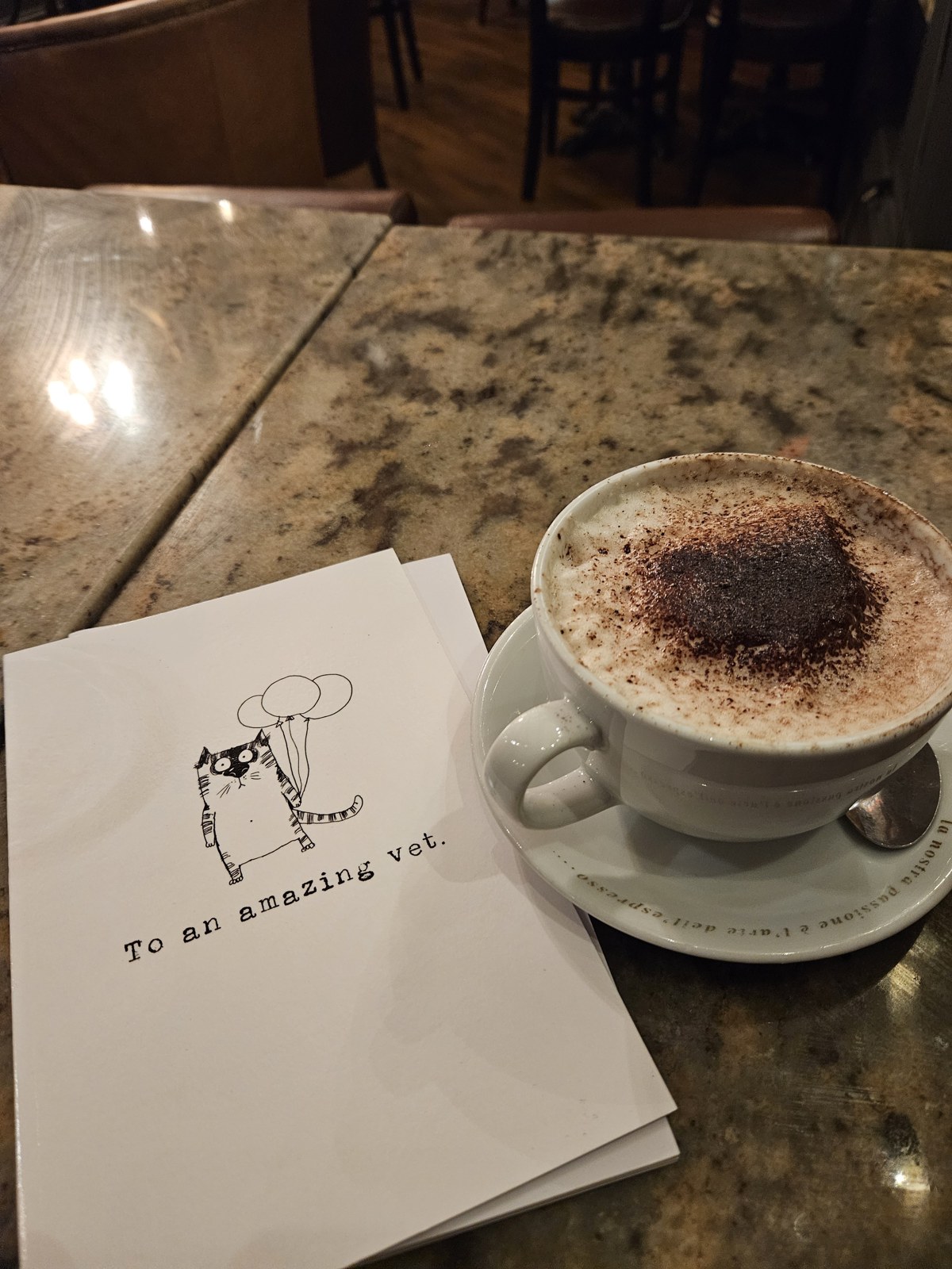A cappuccino beside a card reading To an amazing vet nurse