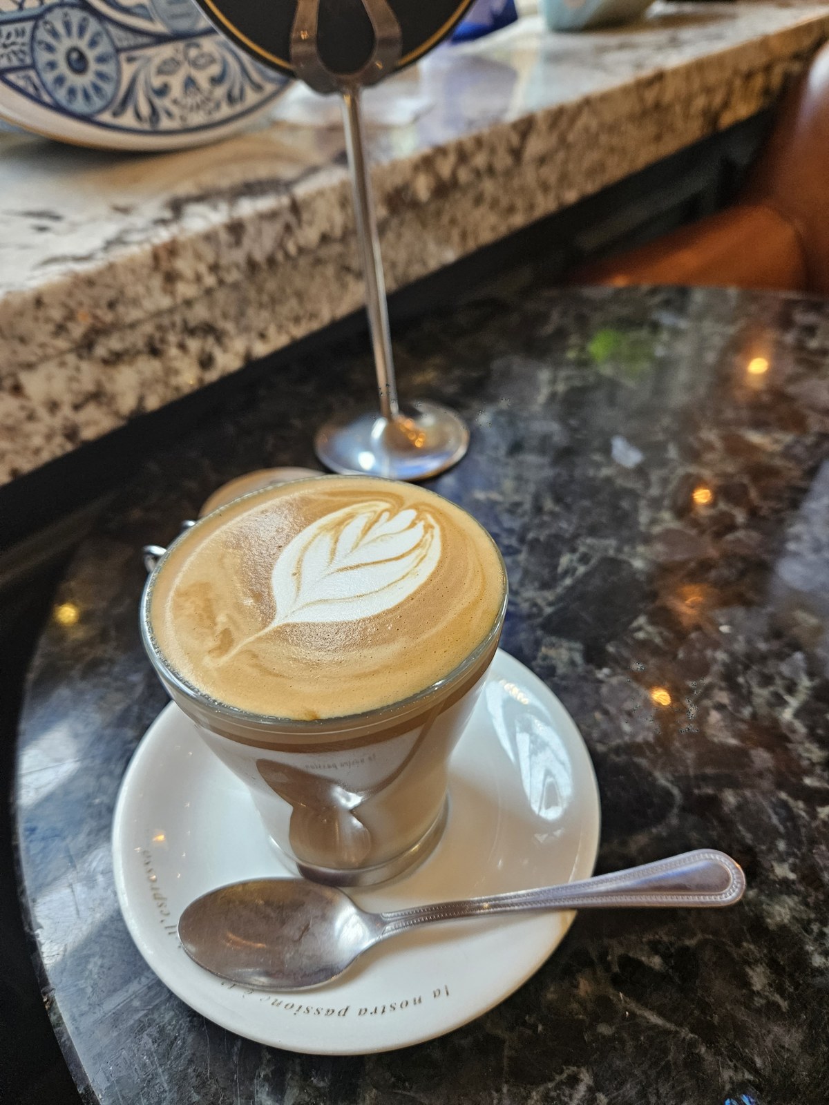 A latte being poured on a café counter